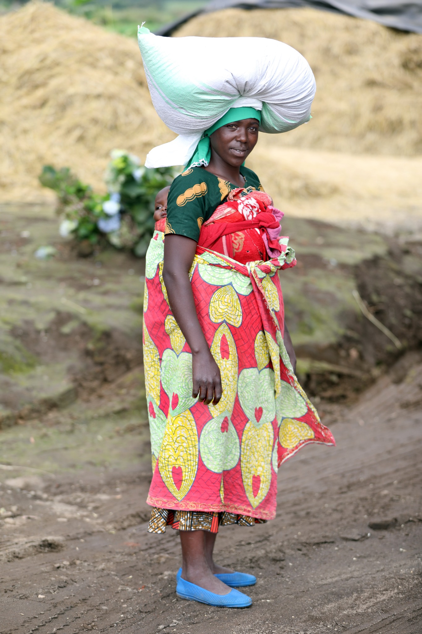 African woman carrying a child and goods photographed by Corey Fader